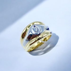 Anello a fascia in oro bianco e giallo con brillante